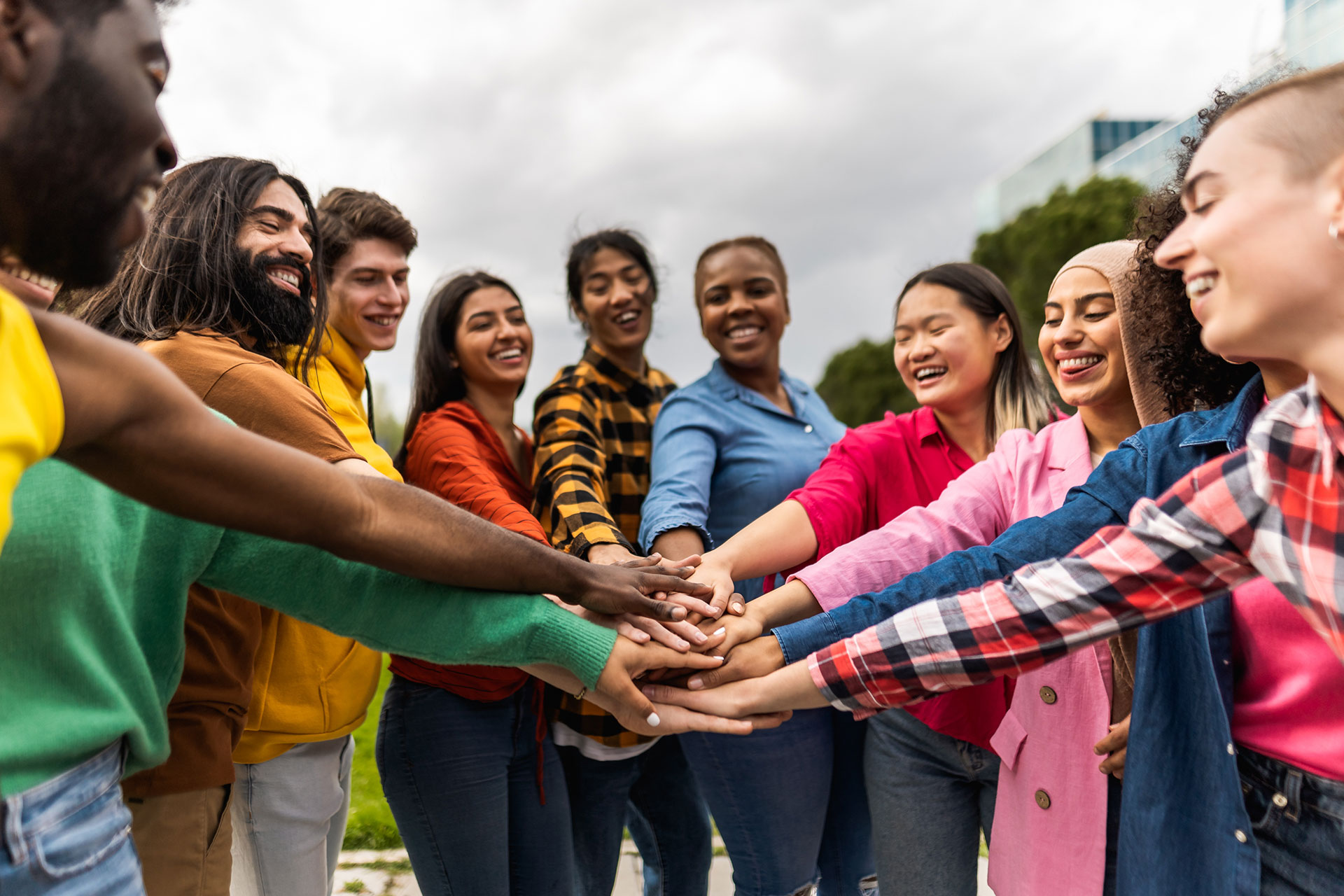 A group of youth putting their hands together in celebration